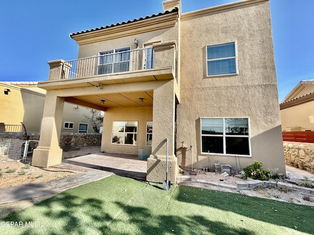 11609 Saint Thomas Way, El Paso, TX 79936 - rear view of property with a balcony, stucco siding, a patio, and a lawn