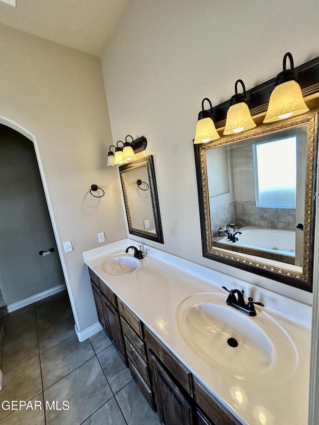 11609 Saint Thomas Way, El Paso, TX 79936 - bathroom featuring tile patterned floors, a garden tub, double vanity, and baseboards