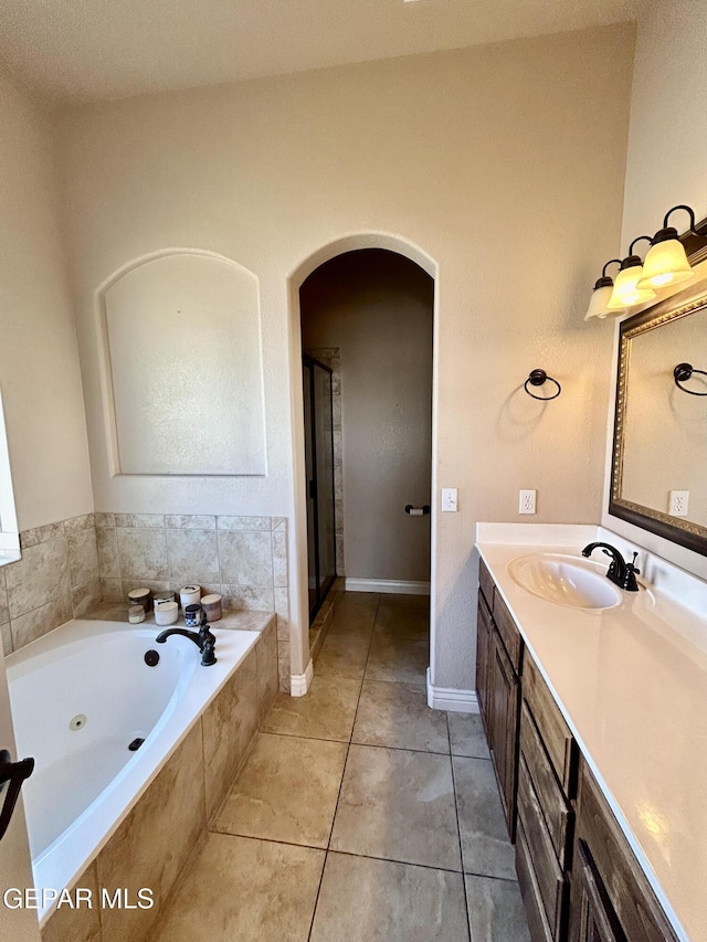 11609 Saint Thomas Way, El Paso, TX 79936 - bathroom featuring vanity, a tub with jets, a stall shower, tile patterned flooring, and baseboards