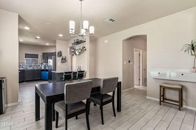 4817 Mark Avizo, El Paso, TX 79938 - dining room with arched walkways, a chandelier, wood finish floors, baseboards, and recessed lighting