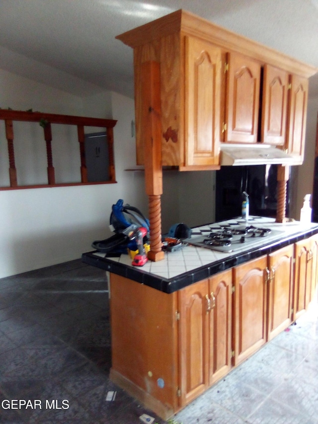 929 Coach Rd, Canutillo, TX 79835 - kitchen with under cabinet range hood, tile counters, stainless steel gas stovetop, and electric panel