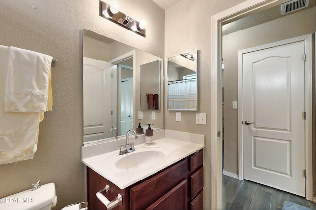 12009 Copper Point Pl, El Paso, TX 79934 - bathroom featuring vanity, wood finished floors, toilet, and a textured wall