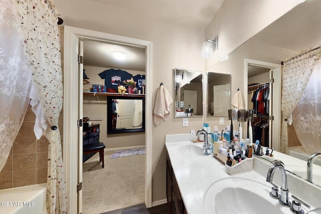 12009 Copper Point Pl, El Paso, TX 79934 - full bathroom with a walk in closet, baseboards, double vanity, and shower / tub combo
