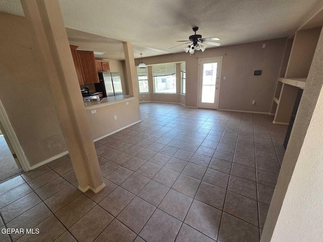 PPP10049 Paloma Dr, El Paso, TX 79924 - unfurnished living room with a textured ceiling, dark tile patterned flooring, ceiling fan, and baseboards