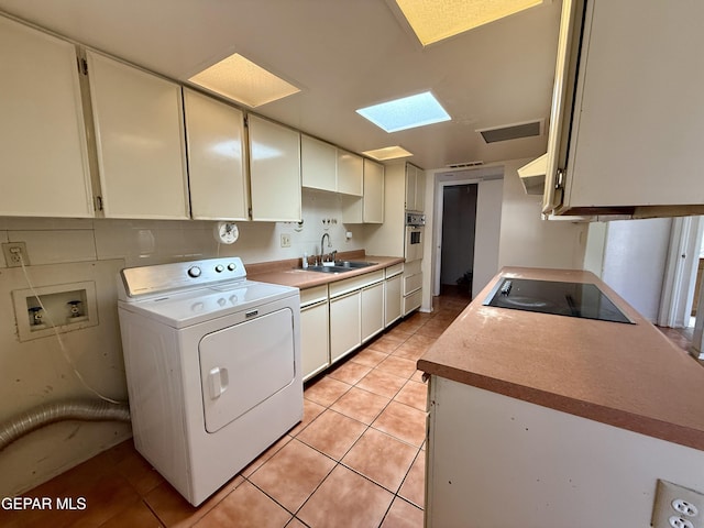 3216 Drumond Rd, El Paso, TX 79925 - kitchen featuring washer / dryer, black electric cooktop, a sink, stainless steel oven, and light tile patterned flooring