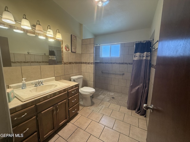 3216 Drumond Rd, El Paso, TX 79925 - full bath featuring tile walls, tile patterned floors, tiled shower, toilet, and vanity