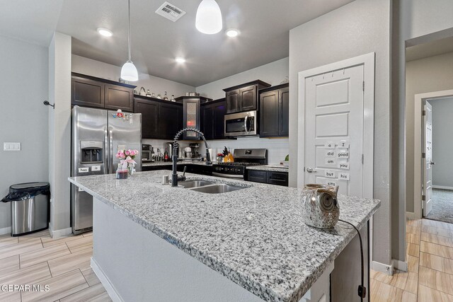 13925 Lago Vista Ave, Horizon City, TX 79928 - kitchen featuring appliances with stainless steel finishes, a sink, baseboards, and light stone counters