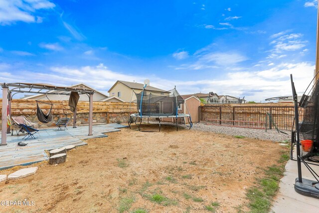 13925 Lago Vista Ave, Horizon City, TX 79928 - fenced backyard featuring a trampoline and a wooden deck