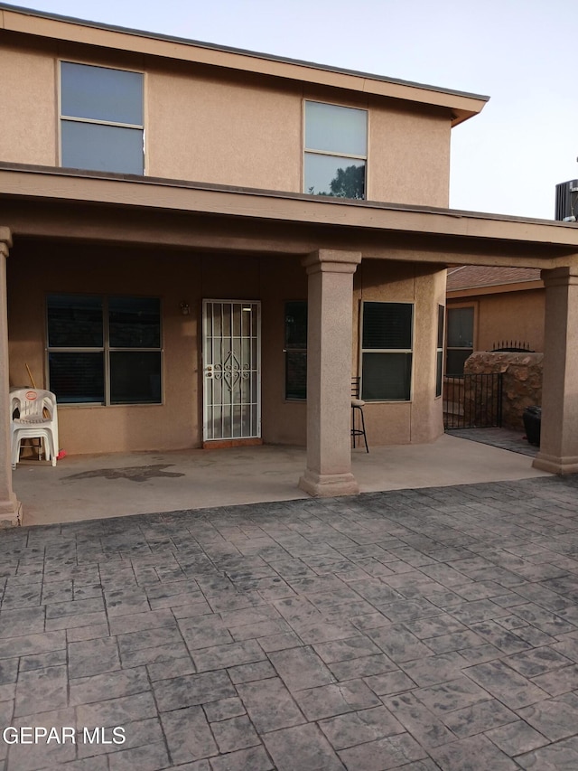 405 Santorini Ct, Socorro, TX 79927 - rear view of house with stucco siding and a patio