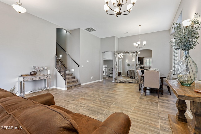 12517 Winners Cir, El Paso, TX 79928 - living room with arched walkways, a chandelier, a high ceiling, stairway, and baseboards