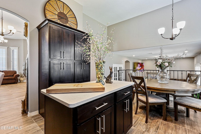 12517 Winners Cir, El Paso, TX 79928 - kitchen with a chandelier, arched walkways, light countertops, hanging light fixtures, and a towering ceiling