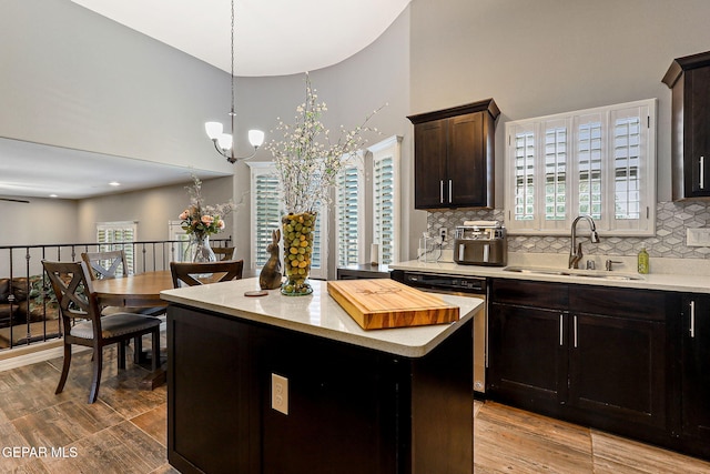12517 Winners Cir, El Paso, TX 79928 - kitchen featuring a towering ceiling, a sink, dishwashing machine, backsplash, and a chandelier