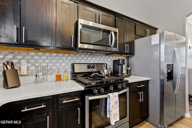 12517 Winners Cir, El Paso, TX 79928 - kitchen featuring appliances with stainless steel finishes, tasteful backsplash, dark brown cabinetry, light wood-type flooring, and light stone counters