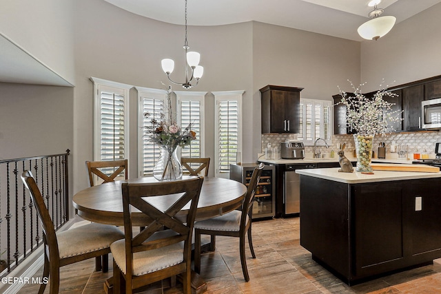 12517 Winners Cir, El Paso, TX 79928 - kitchen featuring beverage cooler, light countertops, a chandelier, decorative backsplash, and a high ceiling
