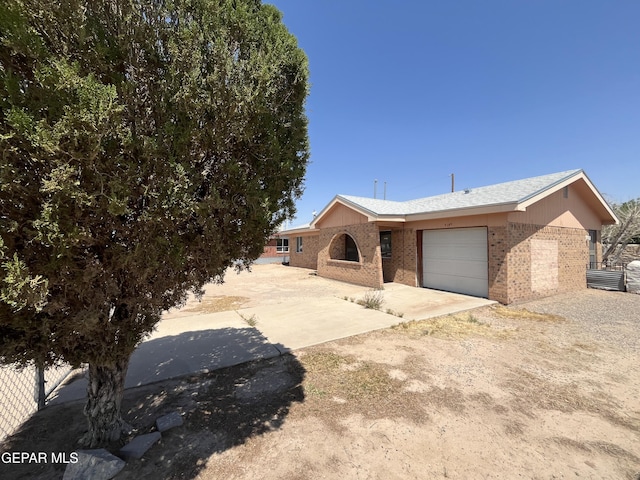9145 Plymouth Dr, El Paso, TX 79907 - ranch-style house featuring an attached garage, brick siding, and dirt driveway