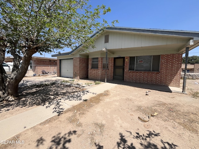 9217 Plymouth Dr, El Paso, TX 79907 - view of front of home with a garage, brick siding, and driveway