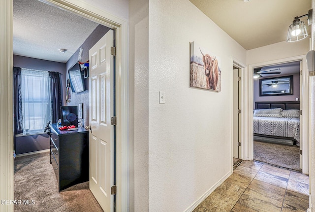 3844 Loma Cortez Dr, El Paso, TX 79938 - hall with baseboards, a textured ceiling, carpet floors, and a textured wall