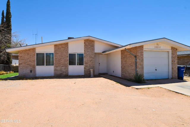 10824 Obsidian St, El Paso, TX 79924 - mid-century modern home with brick siding, an attached garage, and concrete driveway
