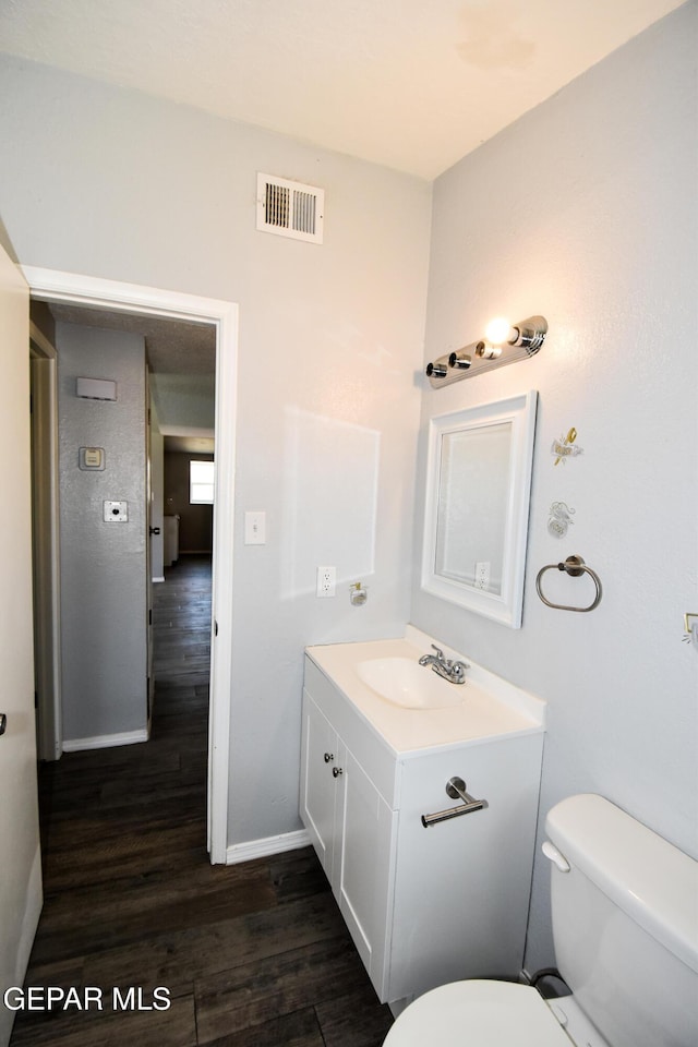 10824 Obsidian St, El Paso, TX 79924 - half bath featuring toilet, wood finished floors, baseboards, and vanity