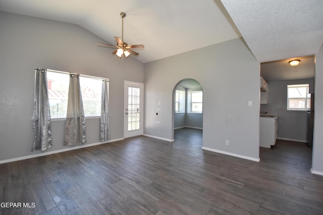 10824 Obsidian St, El Paso, TX 79924 - unfurnished living room with ceiling fan, arched walkways, lofted ceiling, dark wood finished floors, and baseboards