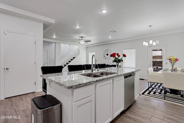 12816 Linstead Ave, El Paso, TX 79928 - kitchen with a sink, stainless steel dishwasher, a chandelier, white cabinets, and light wood-style floors