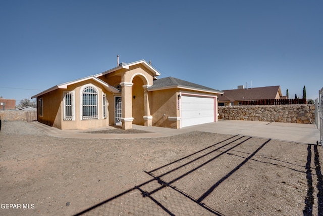 7930 Howard St, El Paso, TX 79904 - single story home with stucco siding, concrete driveway, and an attached garage