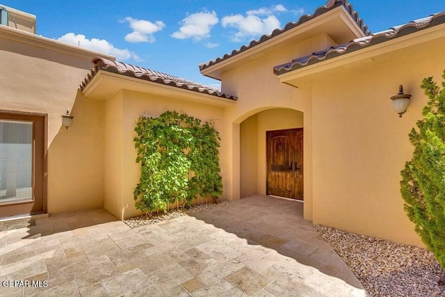 6365 Franklin Trail Dr, El Paso, TX 79912 - view of exterior entry with a tile roof and stucco siding