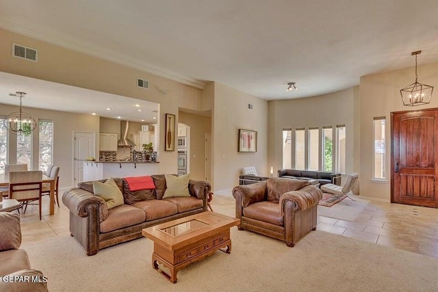 6365 Franklin Trail Dr, El Paso, TX 79912 - living room with a chandelier, light tile patterned flooring, light colored carpet, and ornamental molding