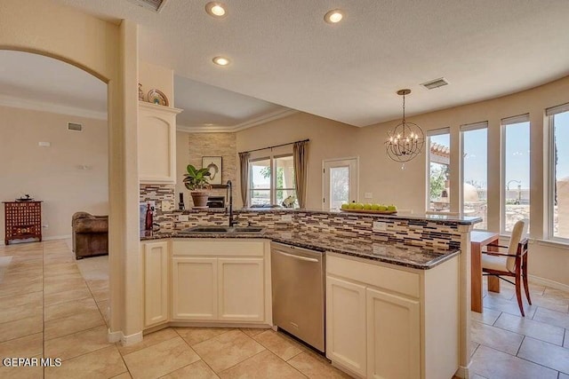 6365 Franklin Trail Dr, El Paso, TX 79912 - kitchen with stainless steel dishwasher, a peninsula, backsplash, dark stone countertops, and a chandelier