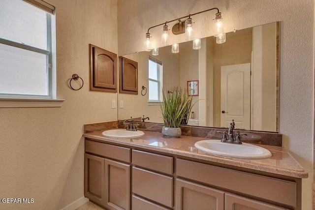 6365 Franklin Trail Dr, El Paso, TX 79912 - bathroom featuring healthy amount of natural light, a textured wall, and double vanity
