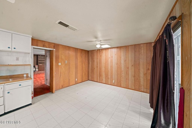 5033 Royal Dr, El Paso, TX 79924 - unfurnished living room featuring wooden walls, light flooring, and ceiling fan