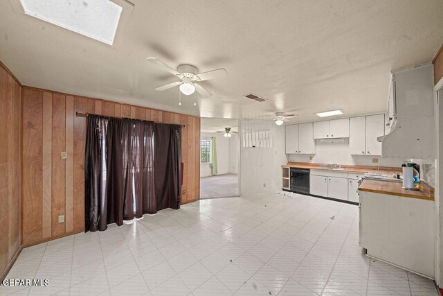 5033 Royal Dr, El Paso, TX 79924 - kitchen with a sink, wine cooler, ceiling fan, wooden walls, and a skylight