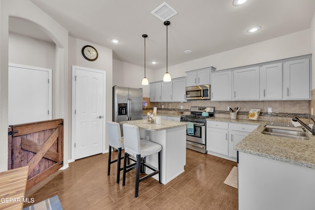 6716 Red Canyon Sage Ln, El Paso, TX 79912 - kitchen featuring stainless steel appliances, a sink, decorative backsplash, a breakfast bar, and a center island