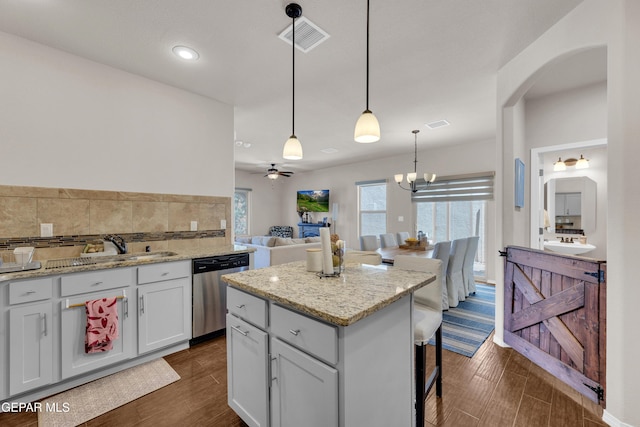 6716 Red Canyon Sage Ln, El Paso, TX 79912 - kitchen featuring dishwasher, arched walkways, dark wood-style floors, a sink, and decorative light fixtures