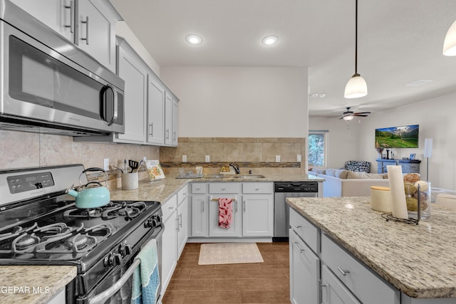 6716 Red Canyon Sage Ln, El Paso, TX 79912 - kitchen featuring appliances with stainless steel finishes, a sink, ceiling fan, dark wood-style floors, and decorative backsplash