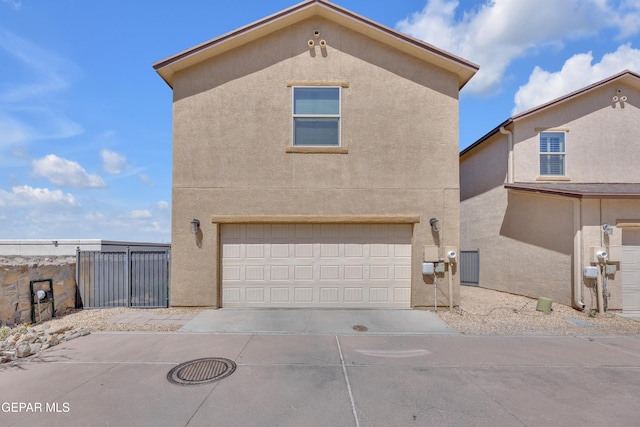 6716 Red Canyon Sage Ln, El Paso, TX 79912 - view of side of home with an attached garage, stucco siding, and concrete driveway