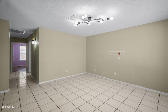 12008 Braveheart Ave, El Paso, TX 79936 - empty room featuring a chandelier, a textured ceiling, light tile patterned flooring, and baseboards