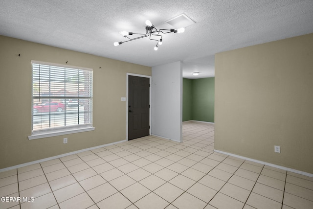 12008 Braveheart Ave, El Paso, TX 79936 - spare room with a chandelier, a textured ceiling, baseboards, and light tile patterned floors