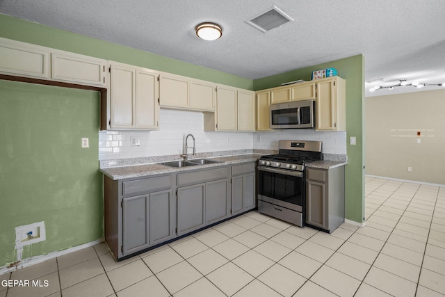 12008 Braveheart Ave, El Paso, TX 79936 - kitchen featuring appliances with stainless steel finishes, a sink, backsplash, a textured ceiling, and light countertops