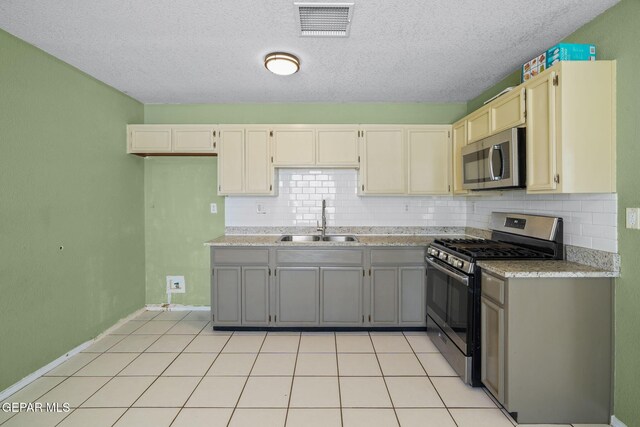 12008 Braveheart Ave, El Paso, TX 79936 - kitchen featuring stainless steel appliances, a sink, backsplash, light countertops, and a textured ceiling