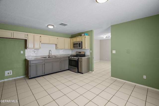 12008 Braveheart Ave, El Paso, TX 79936 - kitchen featuring appliances with stainless steel finishes, a sink, decorative backsplash, light tile patterned floors, and light countertops