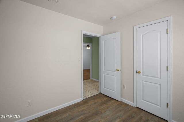 12008 Braveheart Ave, El Paso, TX 79936 - unfurnished bedroom with dark wood-style floors and baseboards