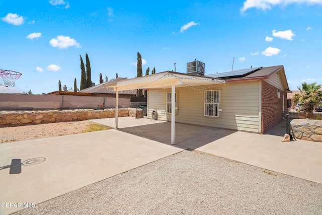 12008 Braveheart Ave, El Paso, TX 79936 - rear view of property with brick siding, roof mounted solar panels, a fenced backyard, a patio, and central AC