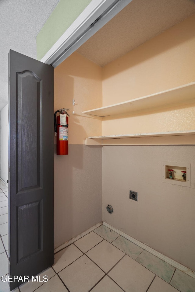 12008 Braveheart Ave, El Paso, TX 79936 - laundry area featuring washer hookup, hookup for an electric dryer, light tile patterned flooring, and baseboards