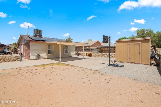 12008 Braveheart Ave, El Paso, TX 79936 - back of property featuring solar panels, a fenced backyard, a patio area, central AC unit, and brick siding