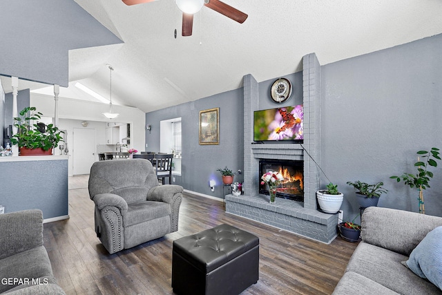12119 Quail Harvest Ln, El Paso, TX 79936 - living area with a ceiling fan, lofted ceiling, a brick fireplace, wood finished floors, and baseboards