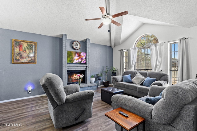 12119 Quail Harvest Ln, El Paso, TX 79936 - living room featuring a textured ceiling, a ceiling fan, dark wood-style flooring, vaulted ceiling, and a fireplace