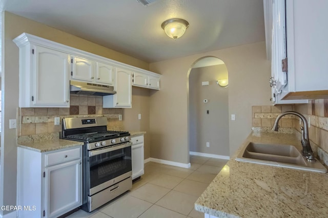 3303 Ward Robert Pl, El Paso, TX 79936 - kitchen featuring stainless steel gas range oven, under cabinet range hood, a sink, arched walkways, and backsplash