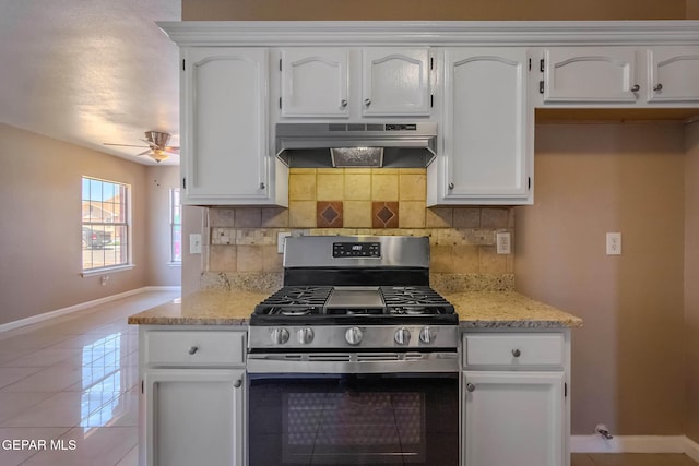 3303 Ward Robert Pl, El Paso, TX 79936 - kitchen with stainless steel gas range oven, under cabinet range hood, baseboards, white cabinets, and tasteful backsplash