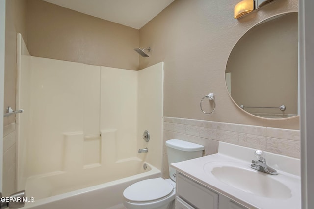 3303 Ward Robert Pl, El Paso, TX 79936 - bathroom featuring tile walls, toilet,  shower combination, wainscoting, and vanity